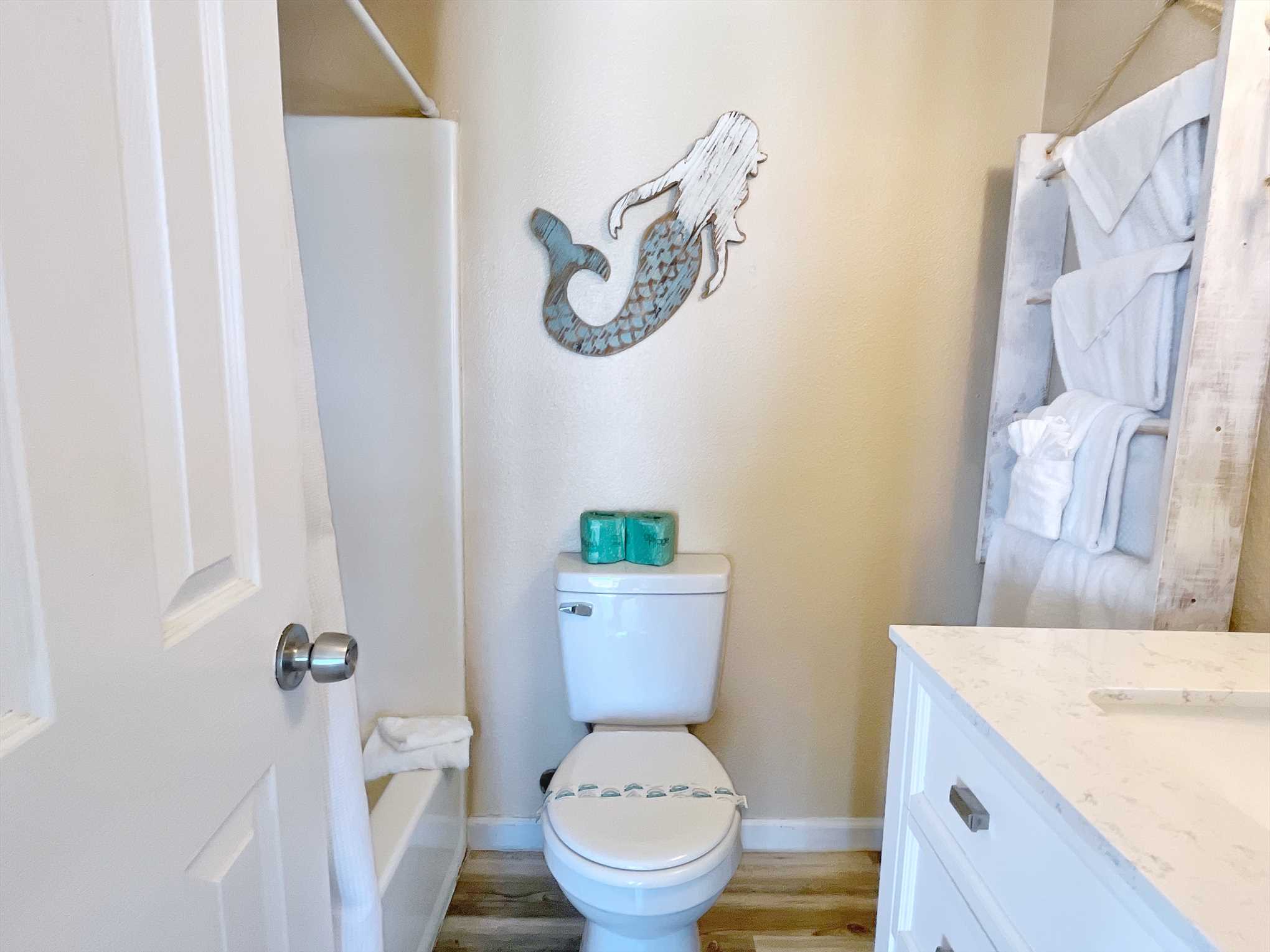 The bathroom with shower/tub combo and towel ladder.
