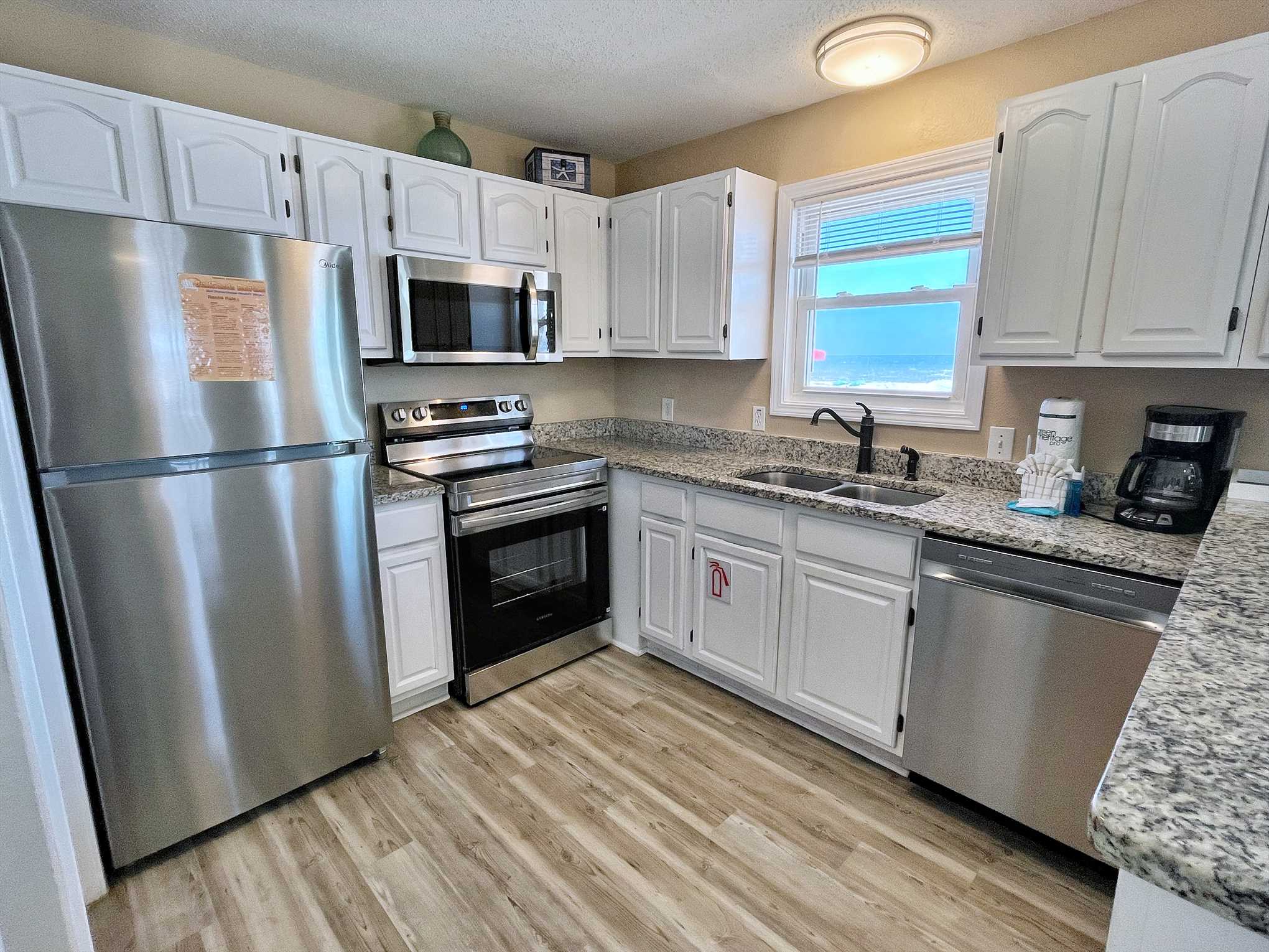 The kitchen includes matching stainless steel appliances and