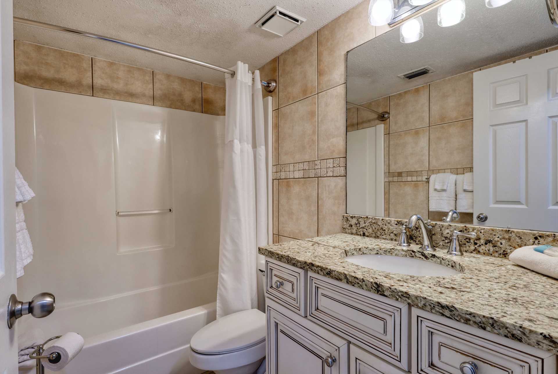 Hallway bathroom - shower/tub combo with granite countertop 
