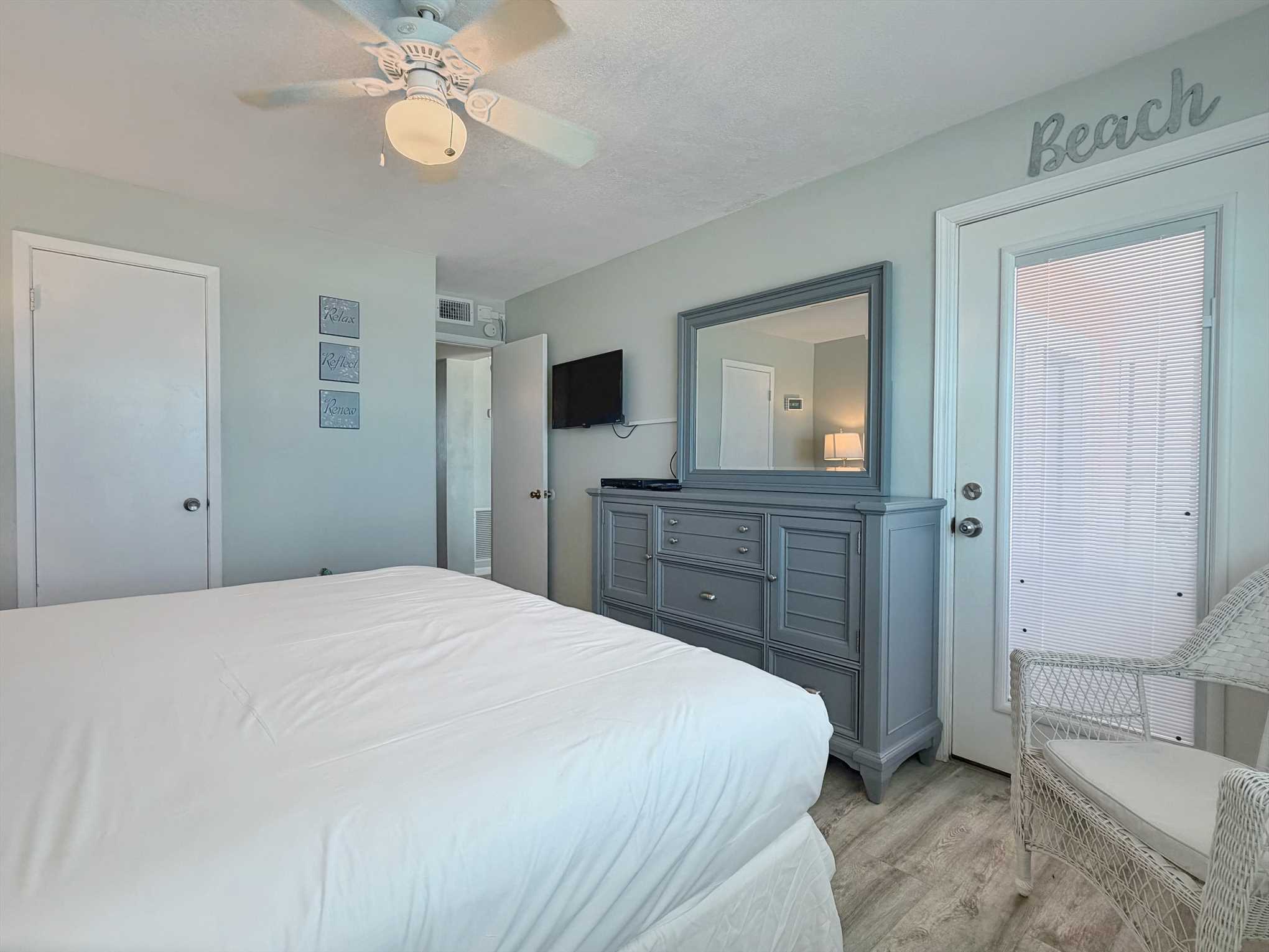 The primary bedroom with a TV, dresser,