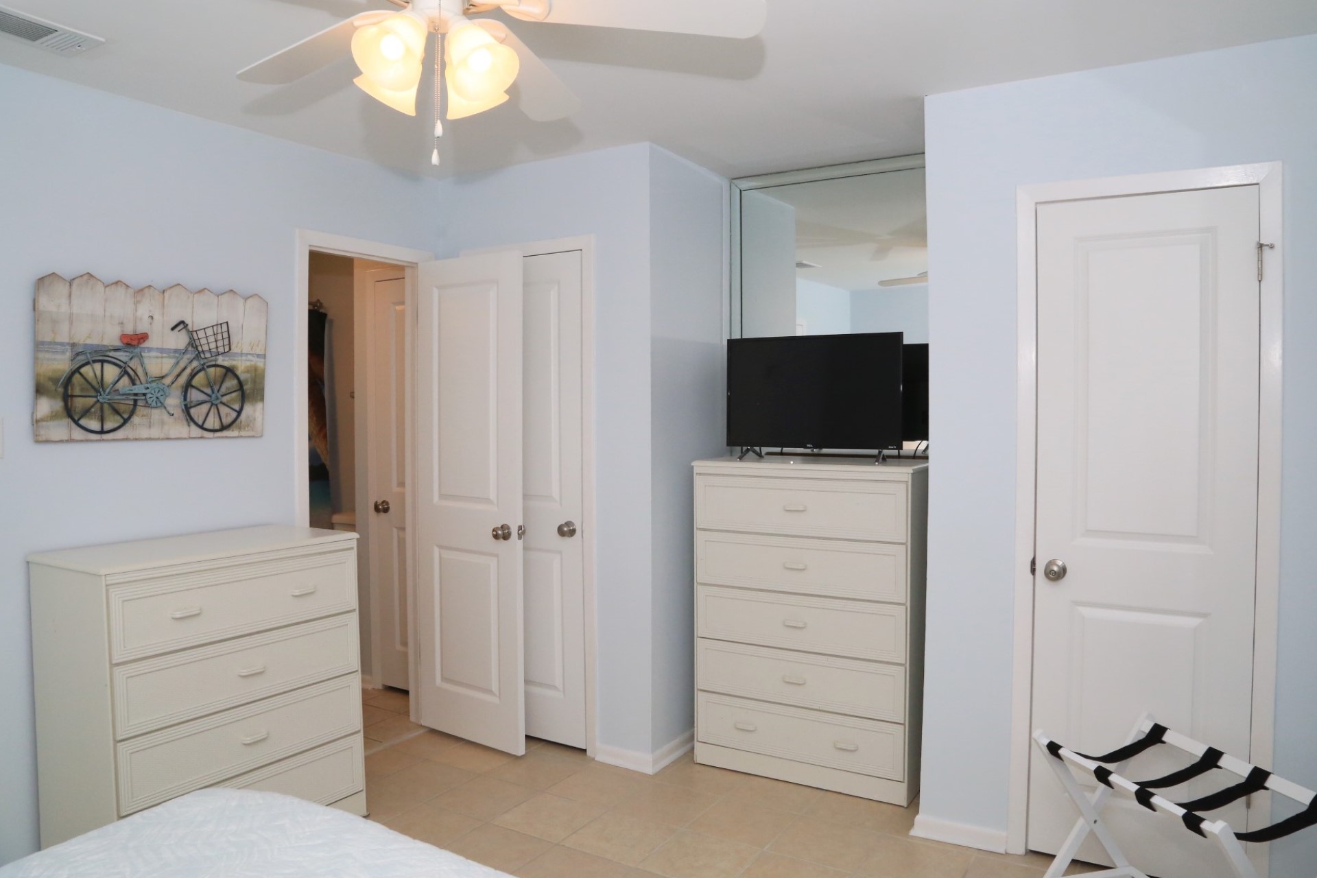 The master bedroom with TV, dressers, and bathroom.
