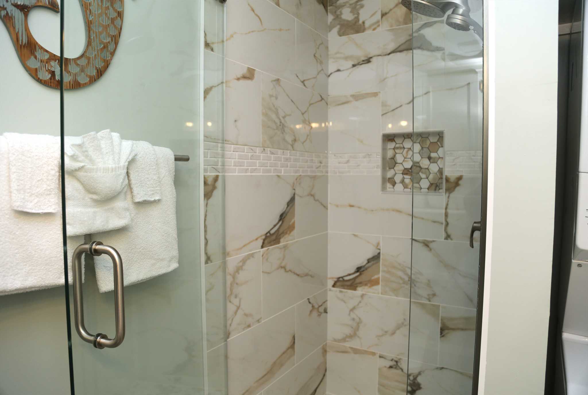 The hall bathroom with a beautifully tiled shower and washer