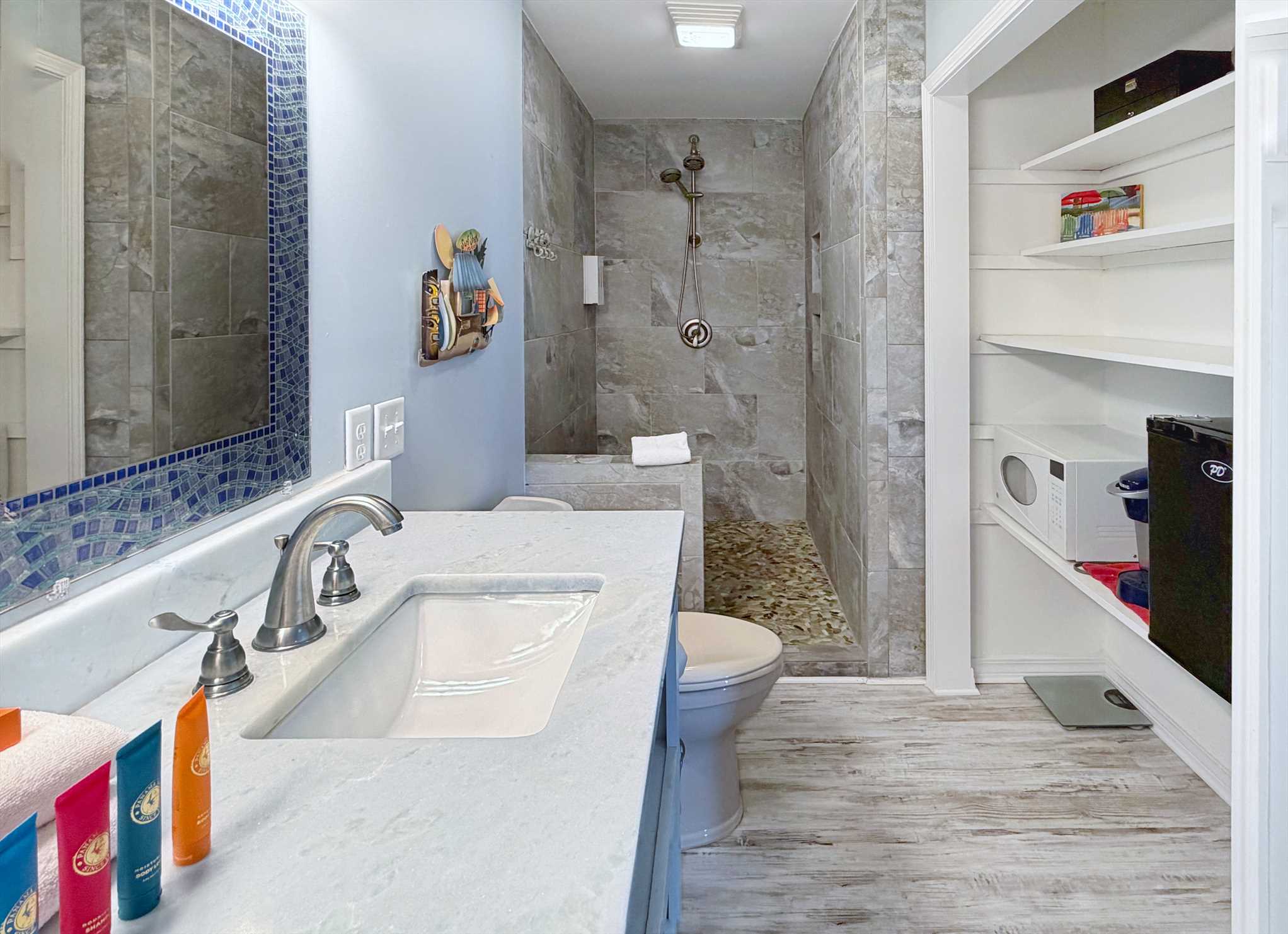 Renovated primary bathroom with custom vanity and tiled show
