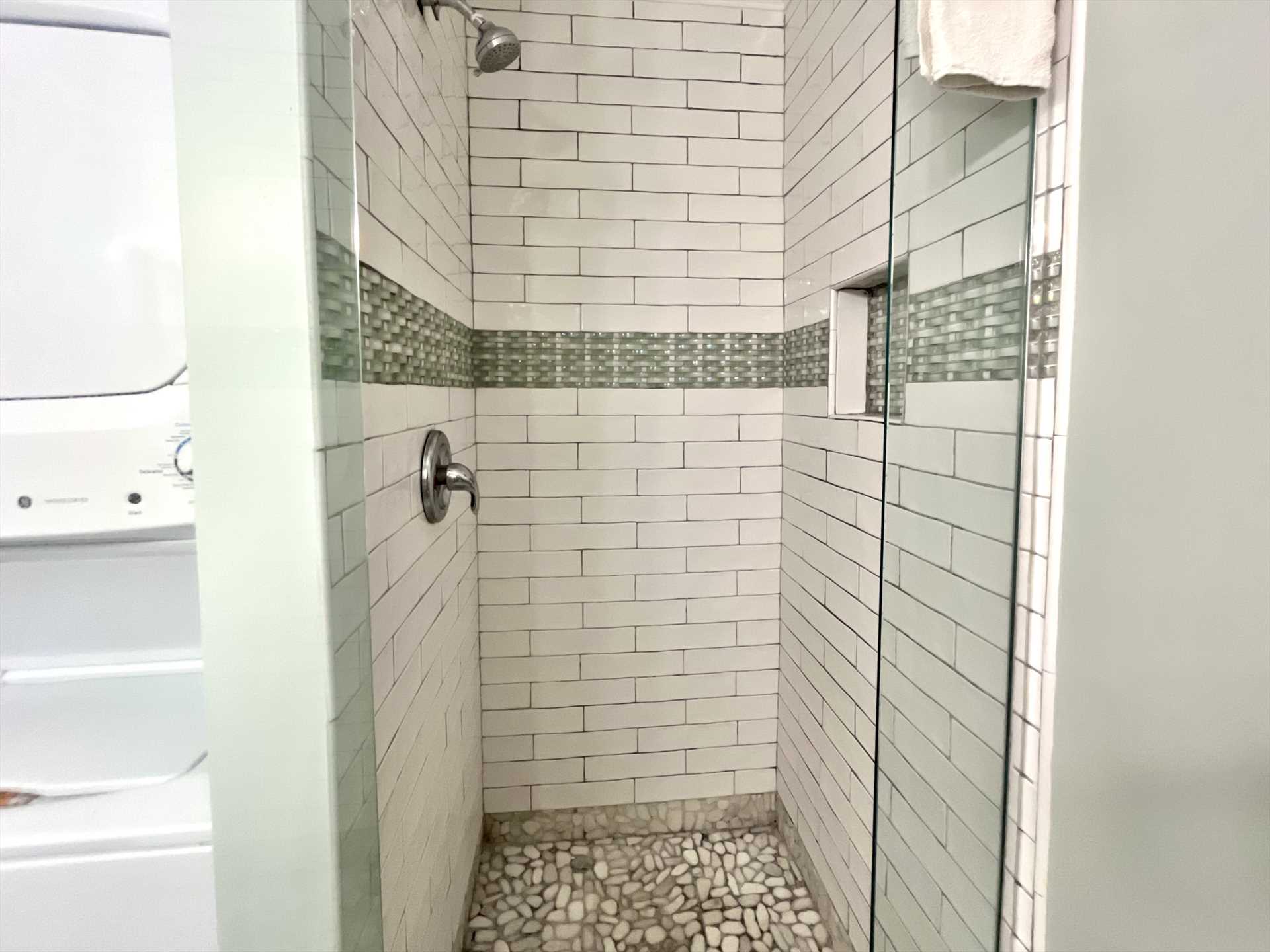 The hall bathroom with a beautifully tiled shower and washer