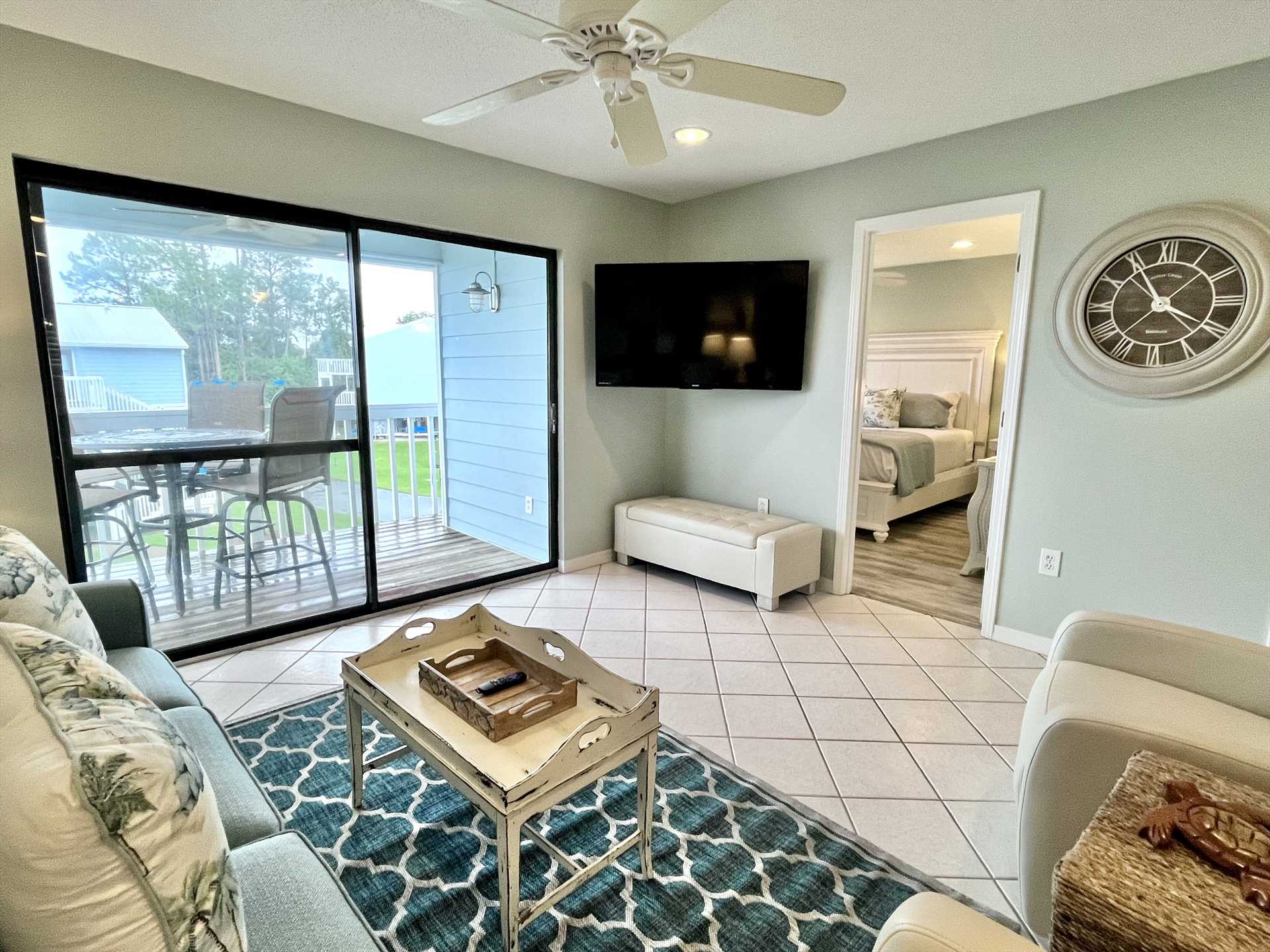 The living room includes a large, flat screen, cable TV.