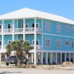 The outside of a 3 bedroom duplex home located in Gulf Shores. The home is blue and located close to the beach